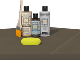 Retique It Black Walnut Kit with Matte Polytique It, Light Wood Wood'n Primer, Black Walnut Gel Stain Alternative, paintbrush, and yellow sponge on a tabletop.