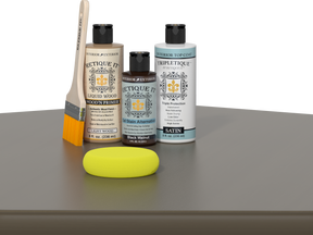 Retique It® Black Walnut kit with brush, Wood’n Primer, satin top coat, and yellow sponge on a wood surface.