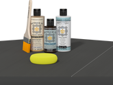 Retique It® Light Wood Wood’n Primer with Charcoal Gel Stain Alternative, matte topcoat, brush, and yellow sponge on a dark tabletop.
