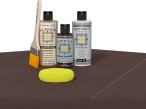 Retique It® Light Wood Wood’n Primer with Java Gel Stain Alternative, matte topcoat, brush, and yellow sponge on a dark tabletop.