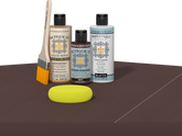 Retique It® Light Wood Wood’n Primer with Java Gel Stain Alternative, matte topcoat, brush, and yellow sponge on a dark tabletop.