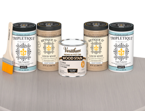 64 oz Retique It Liquid Wood kit with Antique White stain, matte Tripletique topcoat, and a paintbrush on a matching finished tabletop.