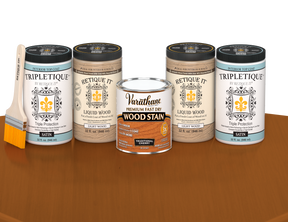 64 oz Retique It Liquid Wood kit with Traditional Cherry stain, satin Tripletique topcoat, and a paintbrush on a matching finished tabletop.