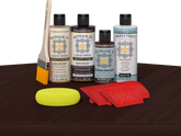 Retique It® Wood'n Finish Kit in Red Mahogany stain displayed on a table, showcasing wood finishing products and application tools.