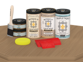 Retique It® Wood'n Finish Kit with four large pickled oak stain bottles for wood finishing, matte finish shown on tabletop.