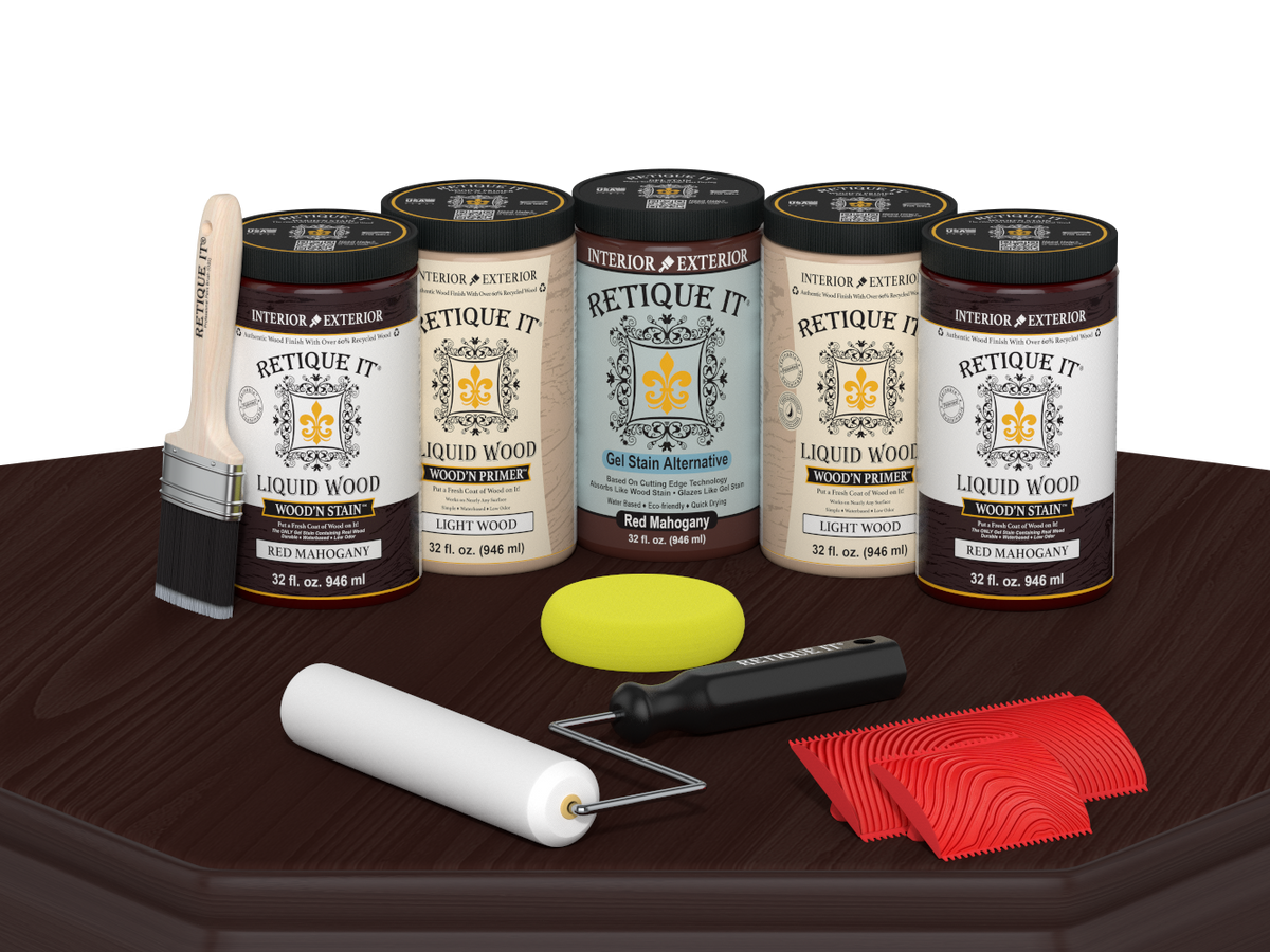 Retique It® Red Mahogany Wood'n Kit featuring Red Mahogany Liquid Wood stain, Light Wood primer, Red Mahogany Gel Stain Alternative, paint brush, white roller, yellow sponge, and red graining tools displayed on a dark wood tabletop.